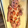Hazel joined the competition — help win amazing prizes! baby, infant, child, romper, bow, headwear, patterned_clothing, strawberry_pattern, smiling, tongue_out, lying_down, changing_pad, soft_lighting, indoors, cute, happy, person, skin, footwear, sock