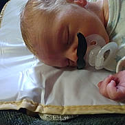 Jesson is registered to the contest to win money with this photo: baby, blanket, closeup, clothing, comfort, cute, face, hand, head, indoors, infant, mustache, nap, newborn, pacifier, peaceful, rest, skin, sleeping, soft_surface