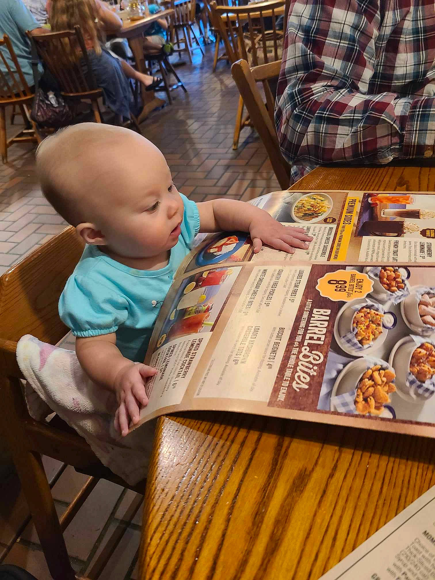 Emery is registered to the contest to win money with this photo: baby, baby_toddler_clothing, chair, child, flooring, font, fun, hardwood, leisure, person, plaid, product, publication, recreation, room, sharing, sitting, table, tartan, toddler