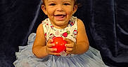 Aria joined the competition — help win amazing prizes! baby, child, toddler, smiling, happy, portrait, sitting, dress, tutu, headband, bow, red_ball, toy, barefoot, dark_background, velvet, indoor, cute, facial_expression, photography