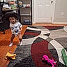 Aria joined the competition — help win amazing prizes! child, toddler, hat, cowboy_hat, smiling, standing, indoor, living_room, wood_floor, area_rug, plush_toy, stuffed_animal, toy, furniture, bookshelf, chair, door, socks, t_shirt, portrait