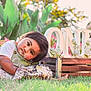 child, baby, cake, messy, grass, outdoor, flowers, greenery, wooden_crate, decorative_letters, one, birthday, celebration, cute, smudged_face, sunlight, nature, portrait, happy, playful