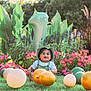 child, toddler, balloon, grass, flowers, pink_flower, number_balloon, greenery, outdoor, sunlight, hat, overalls, smiling, celebration, birthday, nature, garden, happy, person, festive