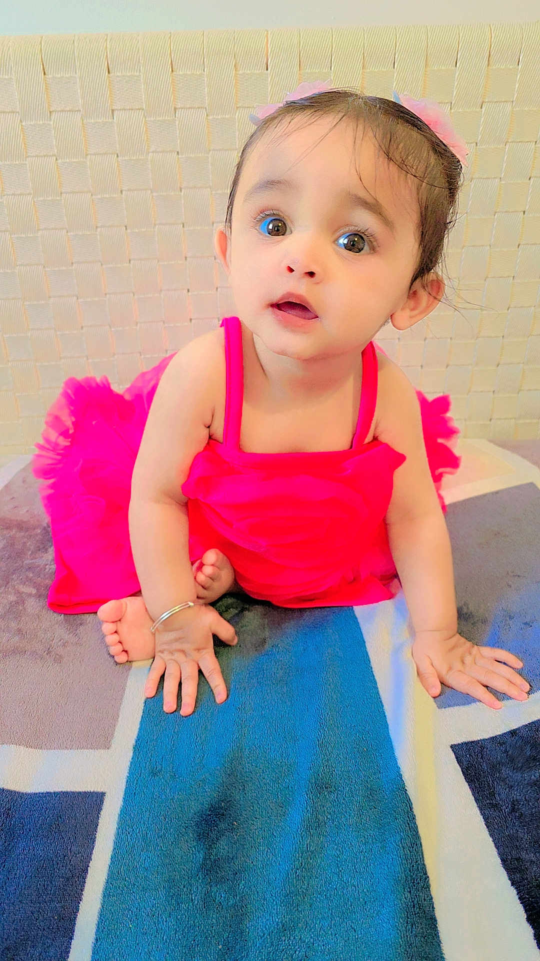 Hezal is registered to the contest to win money with this photo: baby, child, pink_dress, carpet, indoor, curious, sitting, hands, face, eyes, hair, bracelet, foot, portrait, candid, cute, infant, young_child, expression, floor