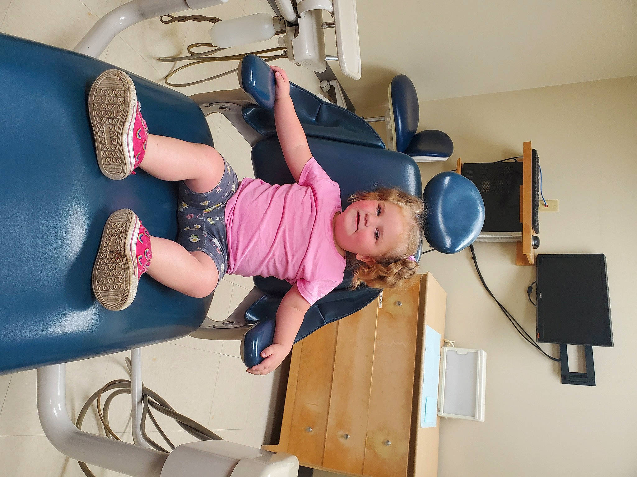 Bianca is registered to the contest to win money with this photo: arm, boot, chair, child, comfort, fun, hat, human_leg, joint, joy, knee, leg, luggage_and_bags, person, room, sandal, shorts, shoulder, sitting, thigh