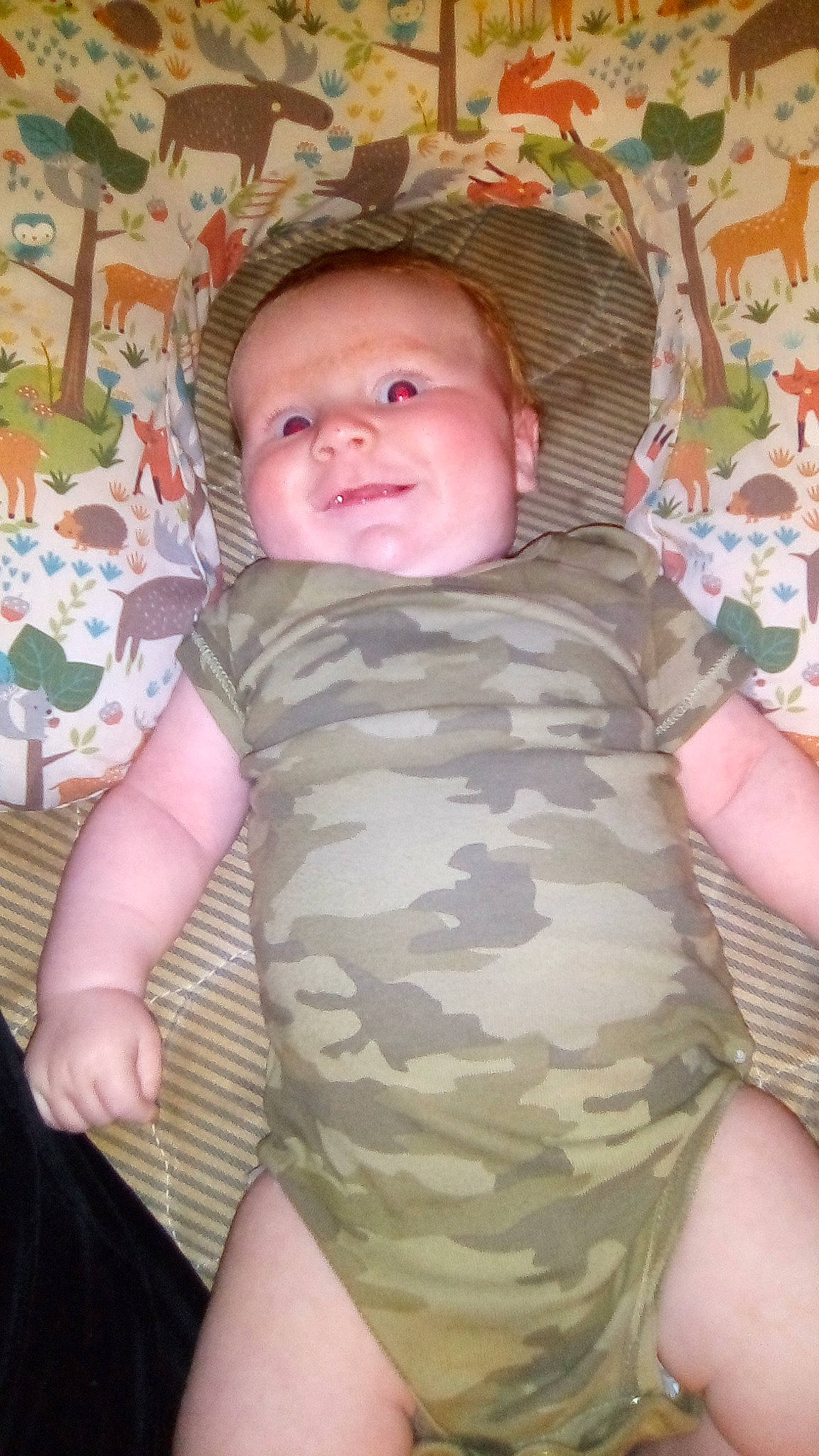 Landyn is registered to the contest to win money with this photo: baby, baby_products, baby_toddler_clothing, camouflage, cheek, child, comfort, eye, finger, head, human_body, joy, linens, military_camouflage, mouth, pattern, person, skin, sleeve, smile