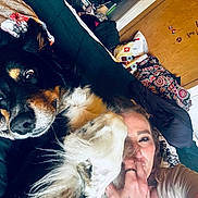 Freddy is registered to the contest to win money with this photo: dog, woman, person, face, smiling, cuddling, paw, fluffy, black_and_tan, pet, companion, selfie, indoor, bed, blanket, cozy, bedroom, furniture, portrait, home