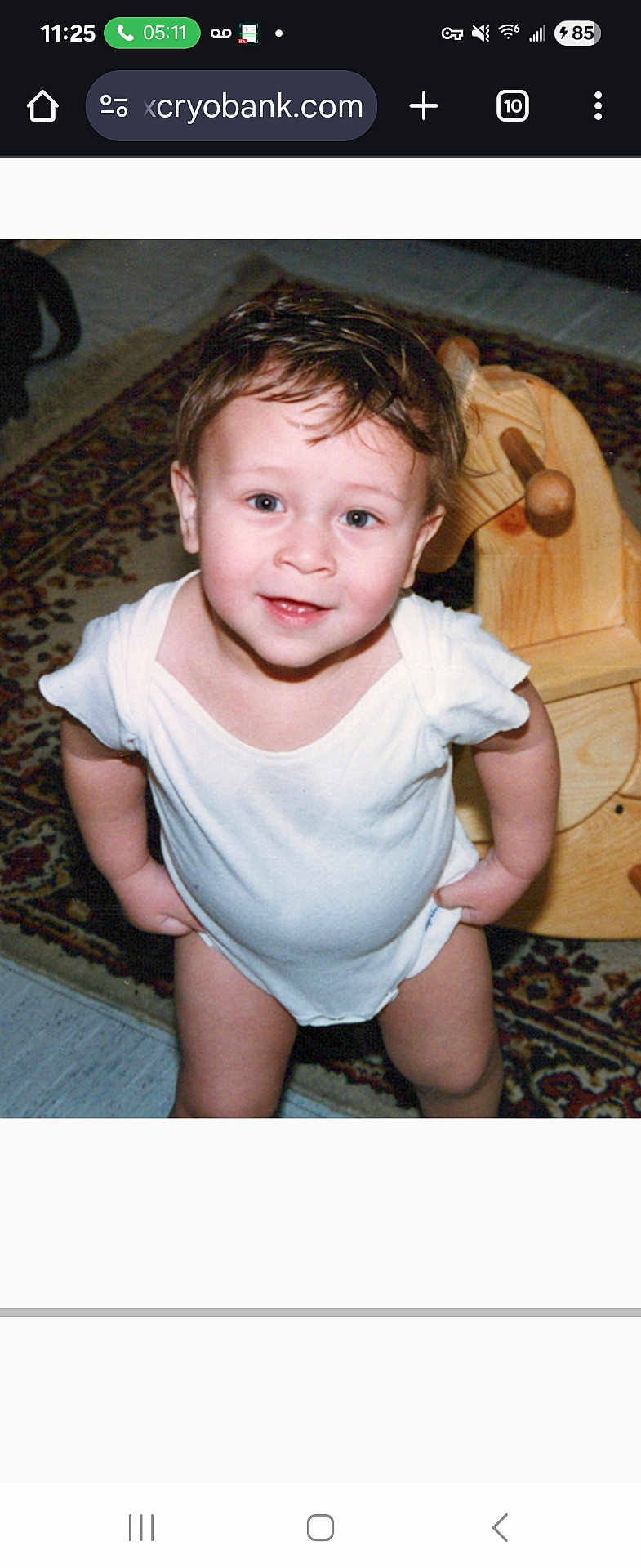 Emmett joined the competition — help win amazing prizes! toddler, child, white_onesie, wooden_rocking_horse, carpet, indoor, smile, short_hair, cute, playroom, floor, toy, portrait, standing, happy, baby, person, home, furniture, expression