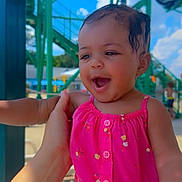 Cimani joined the competition — help win amazing prizes! baby, child, pink_clothing, smiling, outdoor, daylight, water_park, green_structure, hand, happy, playful, summer, sunlight, infant, portrait, clothing, person, face, background, fun