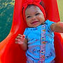 Cimani is registered to the contest to win money with this photo: baby, child, smiling, red_headband, blue_onesie, orange_swing, outdoor, playground, happy, infant, cute, person, toddler, sunlight, grass, plastic_swing, small_hands, colorful, joyful, portrait