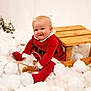 baby, child, red_clothing, wooden_sled, snow_balls, fluffy, pine_trees, winter_theme, festive, smiling, indoors, cute, holiday, playful, portrait, white_background, soft_texture, seasonal, happy, sitting