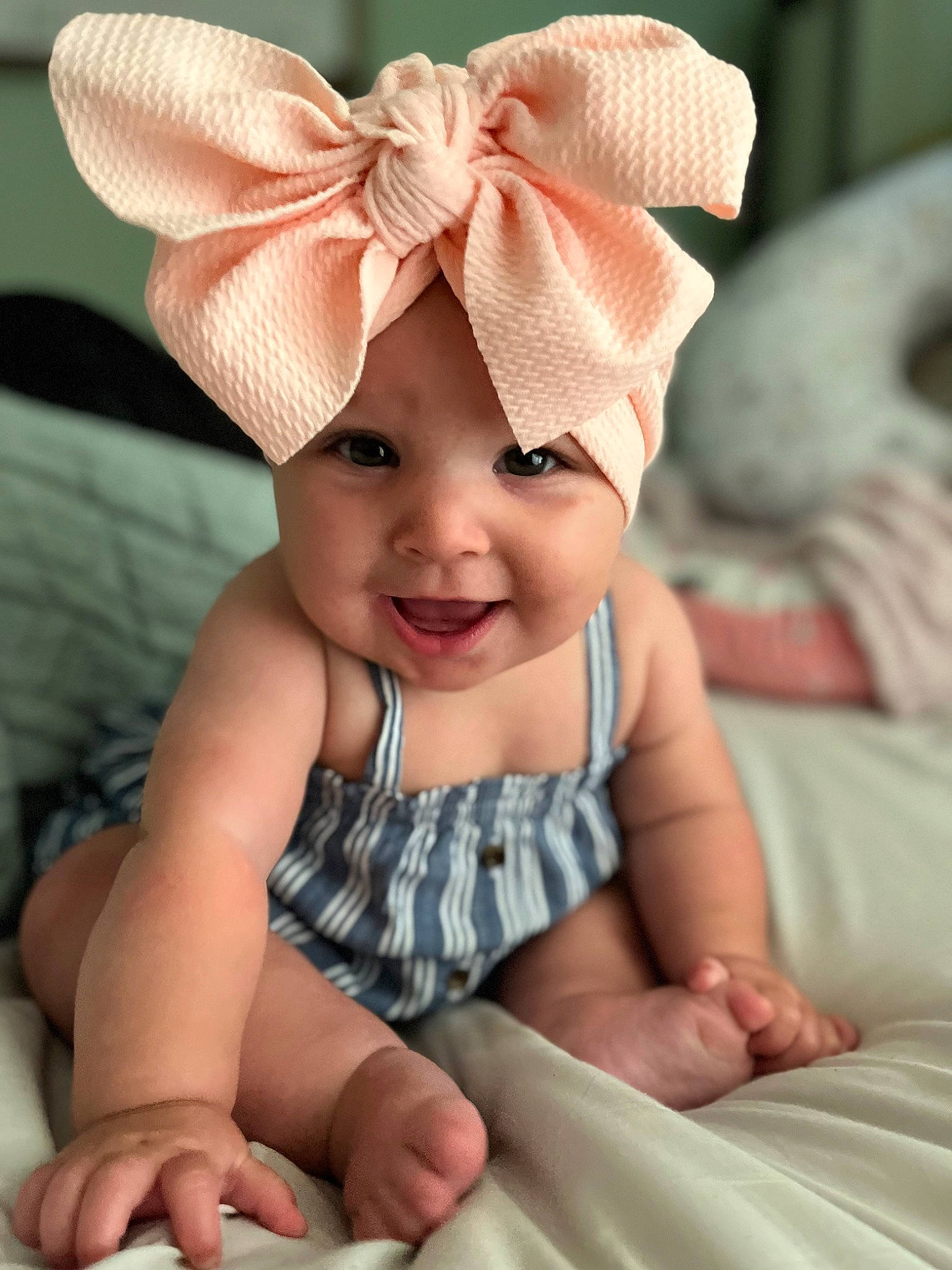 Isabella is registered to the contest to win money with this photo: baby, baby_toddler_clothing, cap, chin, comfort, face, finger, happy, head, headband, headpiece, headwear, human_body, joy, person, photograph, pink, skin, sleeve, smile