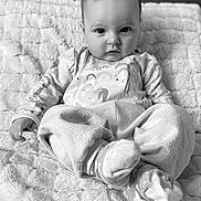 Kayce is registered to the contest to win money with this photo: baby, infant, child, blanket, pajamas, clothing, face, person, sitting, indoor, cute, soft, texture, monochrome, black_and_white, portrait, young, expression, cozy, comfort