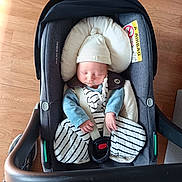 Elio a rejoint le concours — aidez-le/la à gagner de superbes lots ! baby, blanket, bundle, car_seat, child, clothing, cozy, cute, hat, indoor, infant, newborn, peaceful, person, rest, safety_belt, seat, sleeping, striped, wooden_floor