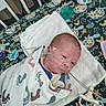 Koda is registered to the contest to win money with this photo: newborn, baby, crib, swaddled, blanket, oxygen_tube, pacifier, turtle_pattern, towel, hospital, infant, face, head, medical, bed, footprint_pattern, calm, lying_down, cute, person
