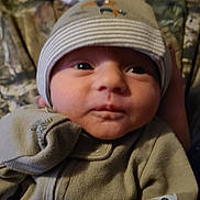 Aspen is registered to the contest to win money with this photo: baby, infant, close_up, face, hat, clothing, beige, cute, newborn, portrait, eyes, hand, soft, indoors, warm, bundle, child, expression, person, cozy
