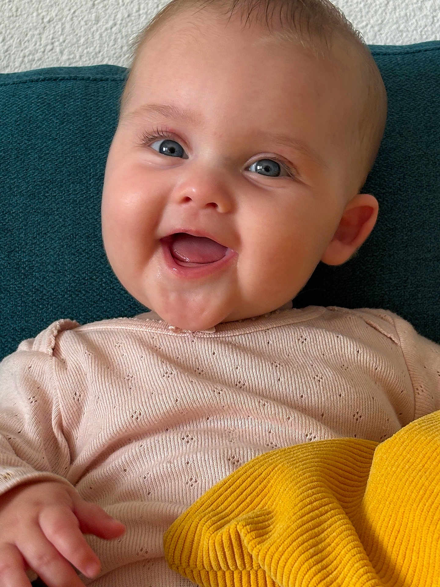 Louise participe au concours pour gagner de l'argent avec cette photo : baby, blue_eyes, child, couch, cozy, cushion, cute, face, hand, happy, head, indoor, infant, person, pink_sweater, portrait, skin, smiling, texture, yellow_blanket