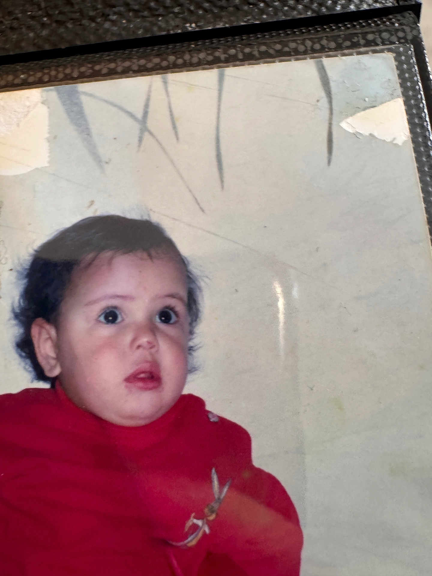 Miral a rejoint le concours — aidez-le/la à gagner de superbes lots ! toddler, child, face, red_sweater, curly_hair, portrait, indoors, expression, looking_away, cute, young_child, person, photograph, nostalgic, old_photo, wear_and_tear, glare, closeup, head_and_shoulders, casual_clothing
