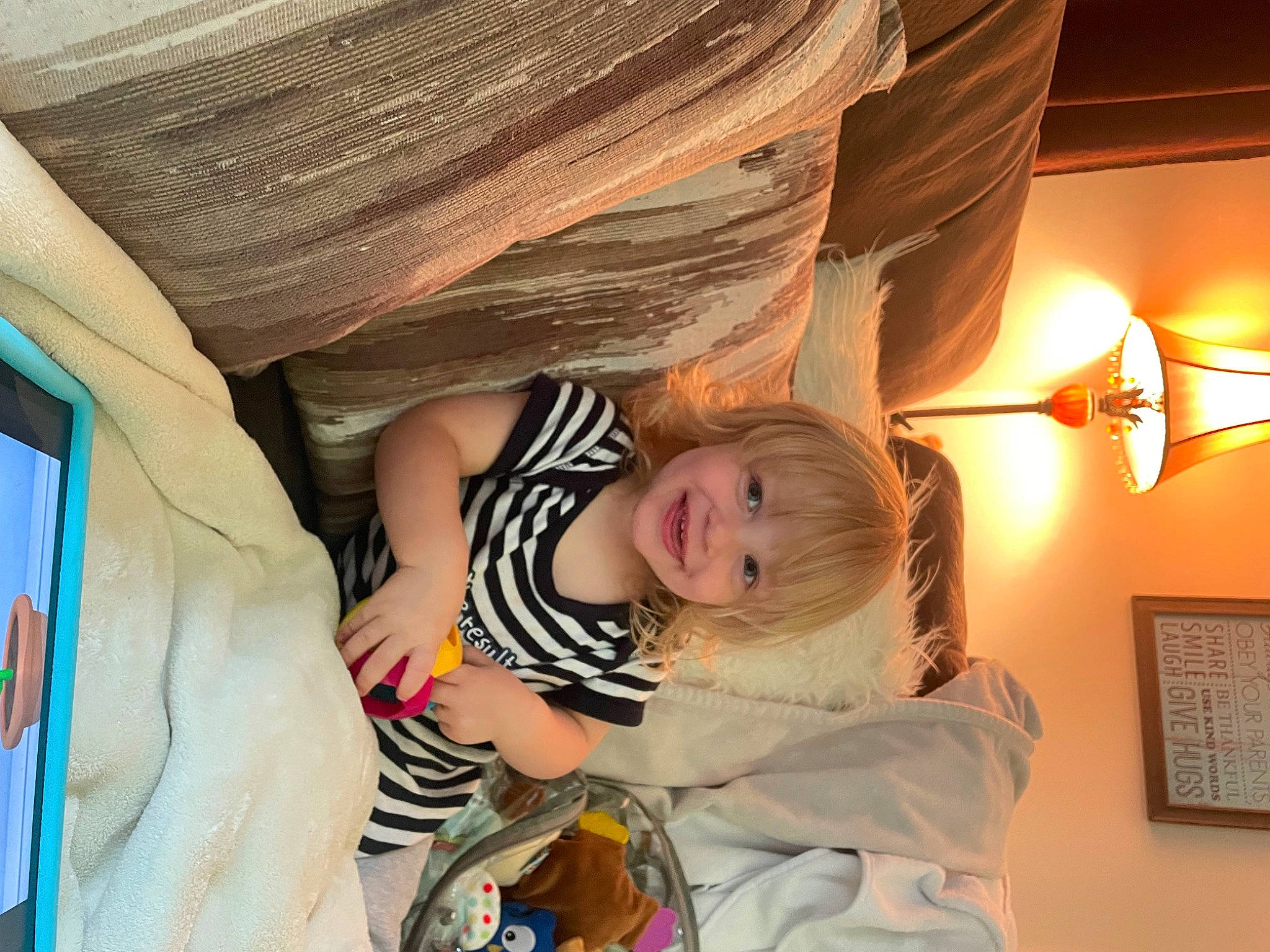 Sebastian is registered to the contest to win money with this photo: baby, baby_products, bed, ceiling, child, comfort, fun, happy, home_accessories, joy, lamp, lampshade, leisure, light_fixture, linens, person, picture_frame, room, sitting, toddler