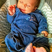 Solal participe au concours pour gagner de l'argent avec cette photo : baby, infant, sleeping, blue_onesie, pink_socks, cushion, seat, chevron_pattern, hand, face, cozy, child, cute, soft_lighting, indoor, clothing, newborn, peaceful, portrait, resting