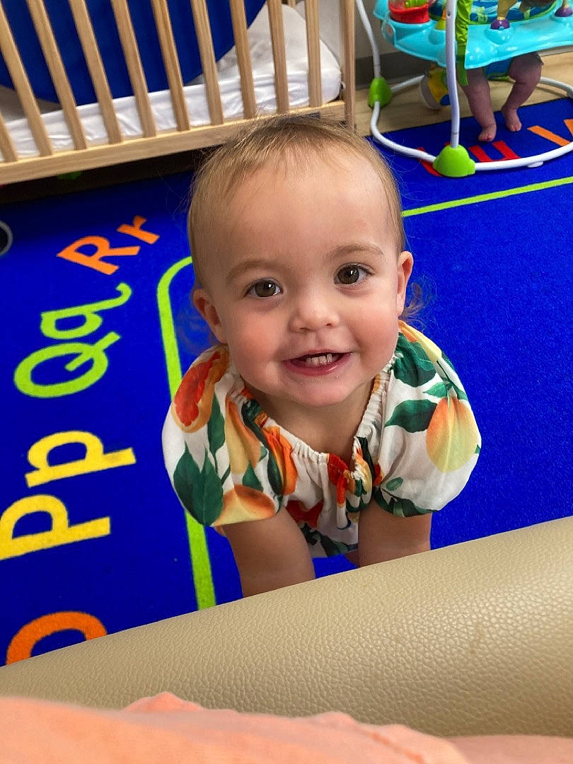 Teegan is registered to the contest to win money with this photo: baby, child, electric_blue, facial_expression, flooring, fun, games, happy, inflatable, joy, leisure, organ, outdoor_play_equipment, person, play, recreation, room, sitting, smile, t_shirt