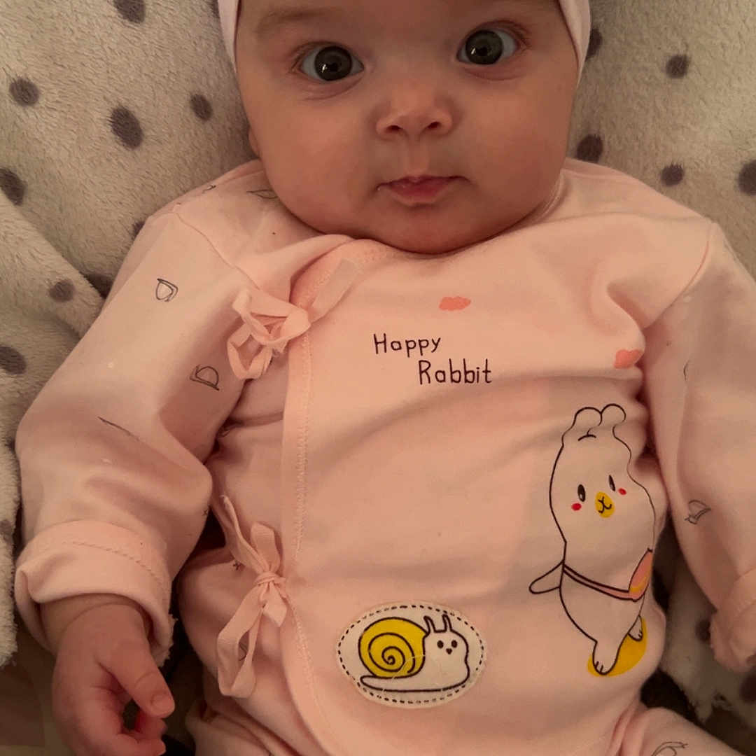 Esra a rejoint le concours — aidez-le/la à gagner de superbes lots ! adorable, baby, baby_clothes, child, closeup, cozy, cute, happy_rabbit, headband, indoors, infant, lying_down, pink_clothing, polka_dot_blanket, portrait, sleepwear, small_hands, smiling_snail, soft_fabric, wide_eyes