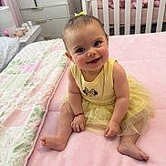 Vida is registered to the contest to win money with this photo: baby, child, infant, smiling, sitting, portrait, nursery, bedroom, crib, bed, pink, yellow, dress, tutu, bow, baby_clothing, barefoot, indoor, happy, photography