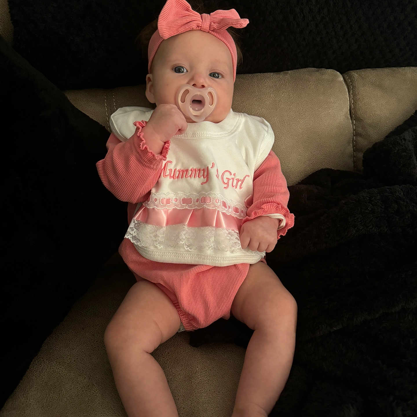 Addison-Rae is registered to the contest to win money with this photo: baby, bodypart, bonnet, clothing, couch, cushion, diaper, face, finger, furniture, hand, hat, head, homedecor, newborn, person, photography, portrait, sitting, t_shirt