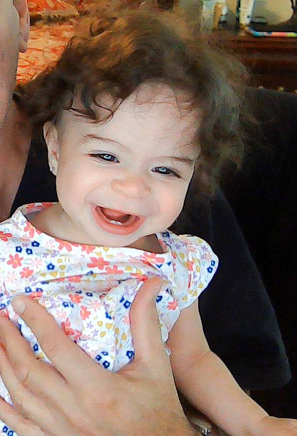 Cali is registered to the contest to win money with this photo: baby, baby_toddler_clothing, cheek, chin, dress, eye, eyelash, finger, flash_photography, fun, gesture, happy, iris, lip, mouth, neck, nose, person, skin, smile