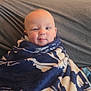 baby, blanket, couch, child, face, head, indoors, person, plush, portrait, smile, winking, wrapped, cozy, soft, seated, home, happy, expression, toddler