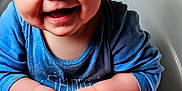 Parker joined the competition — help win amazing prizes! baby, child, blue_eyes, smile, happy, blanket, clothing, sitting, hands, face, cute, infant, portrait, indoors, warm_colors, furniture, person, cozy, expression, closeup