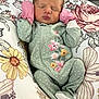 Alaia is registered to the contest to win money with this photo: newborn, baby, infant, sleeping, onesie, mittens, polka_dot, floral_pattern, cushion, soft_fabric, peaceful, cozy, cute, child, portrait, indoor, relaxation, head, face, small_hands