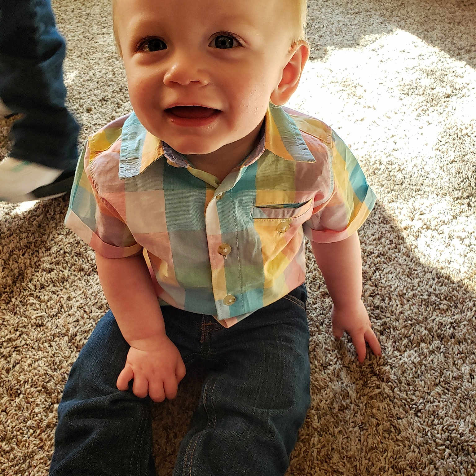 Owen is registered to the contest to win money with this photo: baby, baby_toddler_clothing, cheek, child, face, flooring, fun, grass, head, person, play, sitting, skin, sleeve, smile, t_shirt, toddler