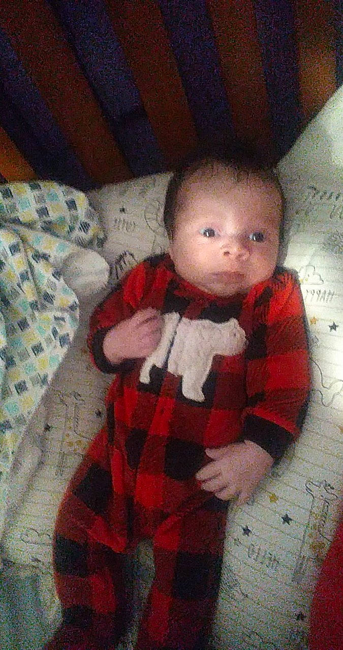 Zayden is registered to the contest to win money with this photo: arm, baby, baby_toddler_clothing, cheek, child, doll, dress, eye, finger, hairstyle, head, human_body, lip, pattern, person, plaid, skin, sleeve, tartan, toy