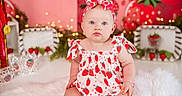 Lakelin joined the competition — help win amazing prizes! baby, child, infant, strawberry, headband, bow, dress, sitting, blue_eyes, pink_background, fairy_lights, decorative, cute, fluffy_rug, portrait, indoor, adorable, young_child, colorful, holiday_theme
