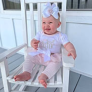 Lakelin is registered to the contest to win money with this photo: baby, child, infant, rocking_chair, white_chair, bow_headband, pink_clothing, easter, smiling, happy, porch, wooden_floor, outdoor, cute, sitting, toddler, headband, white_background, baby_girl, pastel_colors
