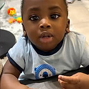 Mathys participe au concours pour gagner de l'argent avec cette photo : baby, child, indoor, curious, blue_shirt, hands, face, eyes, toy, floor, soft_surface, infant, person, cute, expression, young_child, casual_clothing, portrait, closeup, home