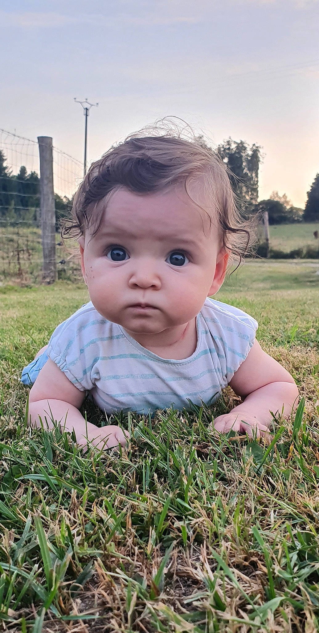 Alice a rejoint le concours — aidez-le/la à gagner de superbes lots ! baby, baby_toddler_clothing, cheek, dress, eye, facial_expression, grass, hairstyle, happy, head, iris, lip, people_in_nature, person, plant, skin, sky, smile, standing, sunlight