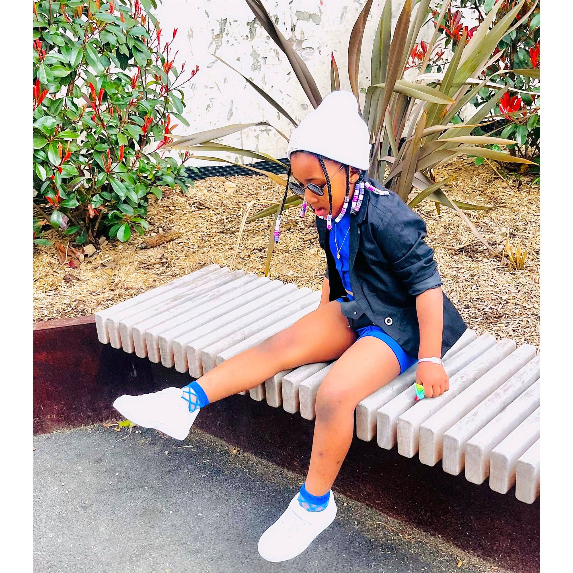 Fanta a rejoint le concours — aidez-le/la à gagner de superbes lots ! beauty, bench, electric_blue, fashion_accessory, foot, grass, hat, human_leg, knee, leisure, outdoor_bench, outdoor_furniture, people_in_nature, person, plant, recreation, rectangle, shorts, sitting, sock