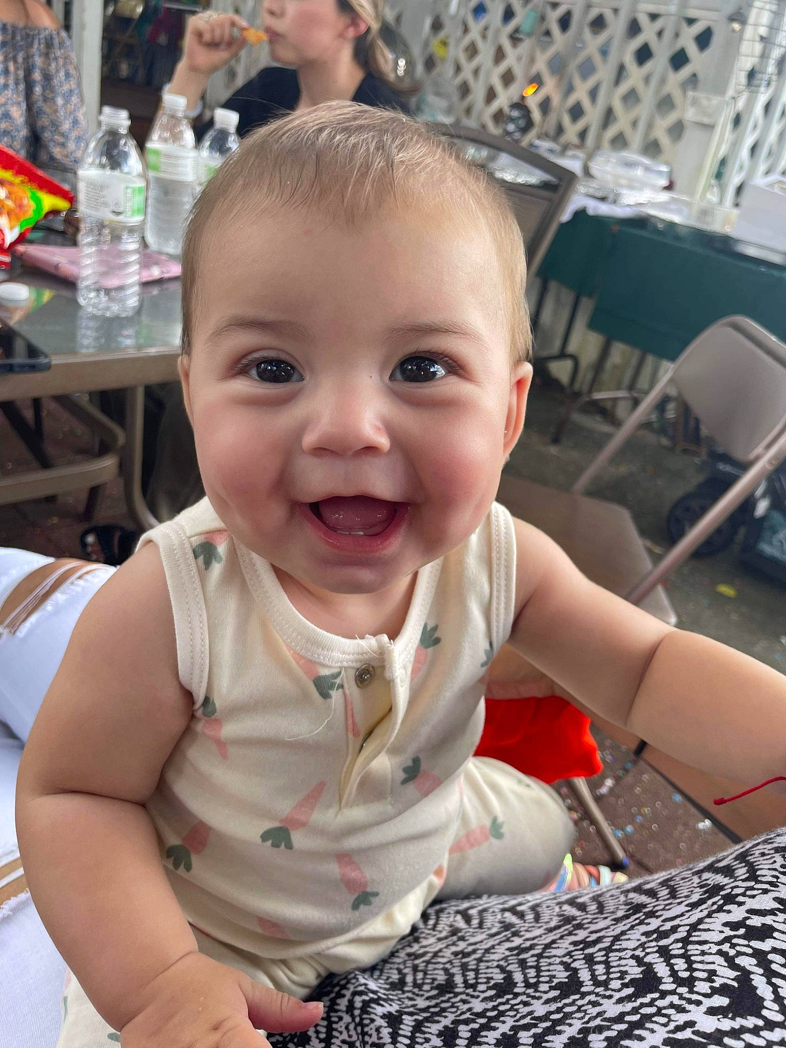 Amani is registered to the contest to win money with this photo: baby, baby_toddler_clothing, chair, cheek, child, eye, face, facial_expression, flooring, fun, gesture, hairstyle, happy, iris, lip, mouth, person, skin, smile, tableware