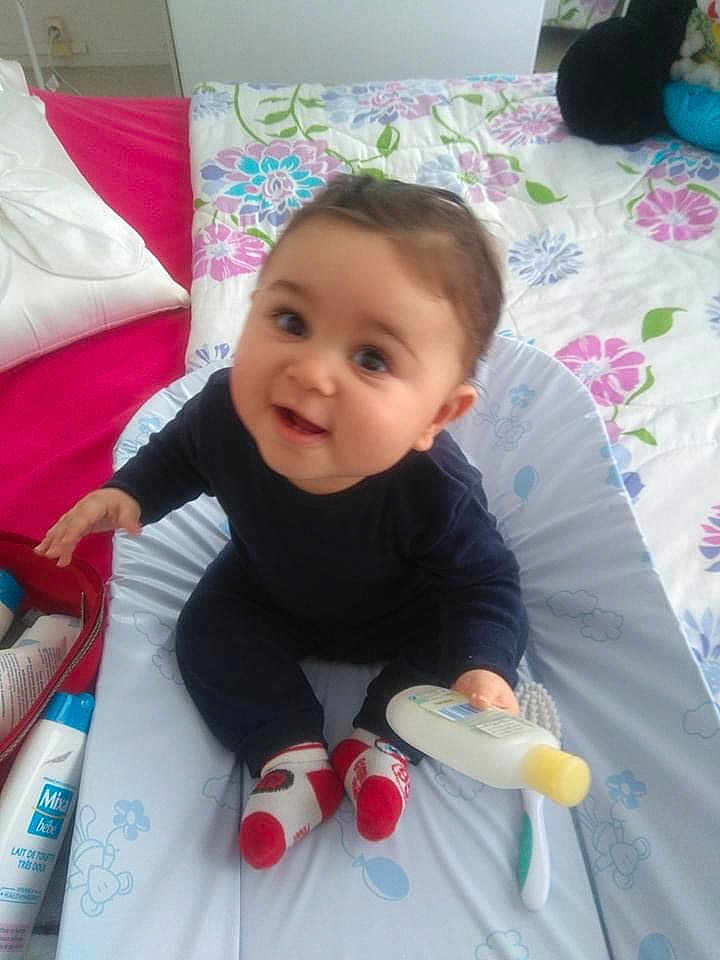 Yazid participe au concours pour gagner de l'argent avec cette photo : baby, infant, child, bottle, socks, changing_mat, bedspread, pillow, baby_care, indoor, person, smiling, clothing, furniture, toy, healthcare, happy, cute, face, sitting