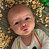 baby, background, bow_tie_print, celebration, cereal, closeup, clothing, colorful, curious, expression, face, food, green_shamrocks, holiday, infant, lying_down, portrait, puckered_lips, texture, white_shirt