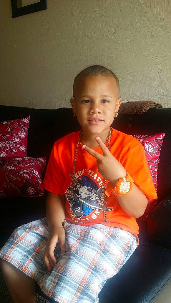 Corie is registered to the contest to win money with this photo: child, comfort, couch, elbow, fun, happy, human_leg, joy, knee, lap, pattern, person, plaid, sitting, sleeve, smile, t_shirt, tartan, thigh, trunk