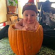 Stefan is registered to the contest to win money with this photo: autumn, baby, chair, child, costume, cute, decor, face, festive, hands, hat, indoor, light, plant, portrait, pumpkin, smile, stroller, tablecloth, window