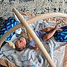 baby, infant, play_mat, baby_toys, soft_toys, plush, cushion, blanket, floor, carpet, child, indoor, person, cute, gaze, blue_clothing, legs, feet, play_gym, relaxing