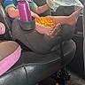 baby_bottle, blonde_hair, car_interior, car_seat, child, clothing, curious, cute, foot, goldfish_crackers, indoor, messy, person, plastic_bag, seatbelt, snack, spill, toddler, vehicle, window