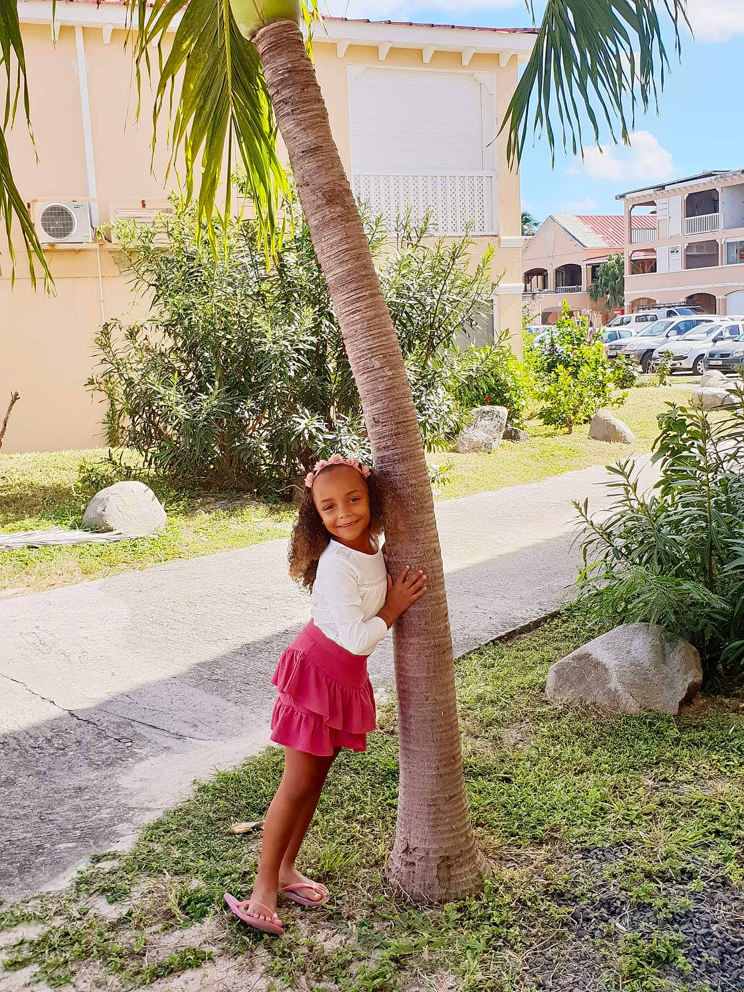 Lola participe au concours pour gagner de l'argent avec cette photo : arecales, beauty, botany, building, event, fun, grass, happy, house, joy, leisure, palm_tree, people_in_nature, person, plant, sandal, sky, smile, summer, toddler