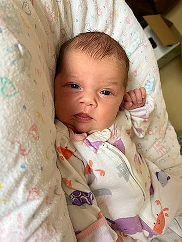 Tiffany is registered to the contest to win money with this photo: baby, baby_products, baby_safety, baby_toddler_clothing, cheek, child, collar, comfort, eye, eyelash, iris, linens, lip, nose, outerwear, person, sitting, skin, sleeve, textile