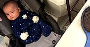 Ezra joined the competition — help win amazing prizes! baby, infant, child, car_seat, onesie, mittens, blue_clothing, portrait, face, indoors, laundry_room, washing_machine, hairbrush, tile_floor, seated, lying_down, looking_at_camera, safe, household, cute