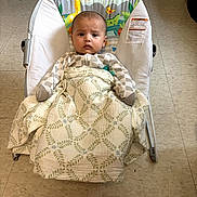 Ezra is registered to the contest to win money with this photo: baby, baby_bouncer, blanket, child, clothing, duck, face, giraffe, indoor, infant, jungle_animals, living_room, owl, patterned_blanket, photography, portrait, sitting, swaddled, tiled_floor, wide_eyed